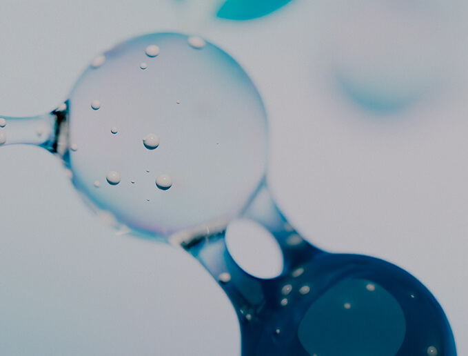 Close-up abstract image of transparent liquid bubbles with a soft blue tint